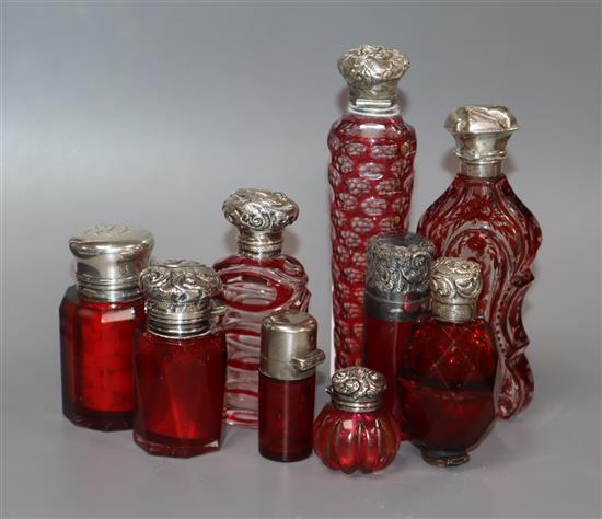 Nine assorted silver or white metal mounted scent bottles.